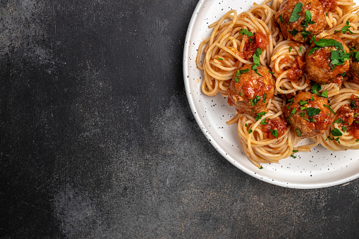 Meatballs served over italian spaghetti pasta with tomato sauce. Italian food. banner, menu, recipe place for text, top view.
