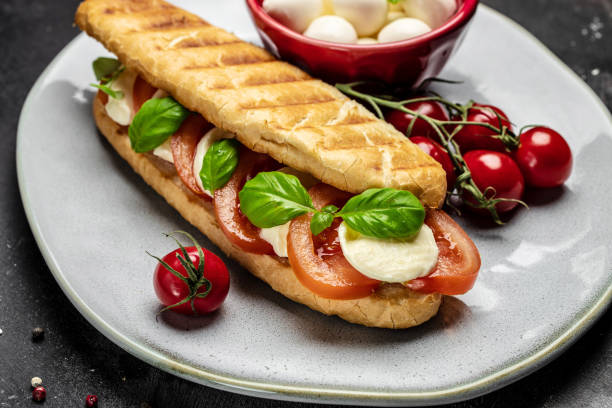 istock Delicious breakfast Caprese Panini Sandwich with tomato, mozzarella and basil, Clean eating, dieting, vegan food concept. top view 1449737567