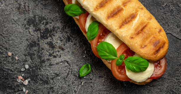 istock Pressed and toasted panini caprese with tomato, mozzarella and basil, Caprese Panini Sandwich. Delicious breakfast or snack, Clean eating, dieting, vegan food concept. top view 1449737571