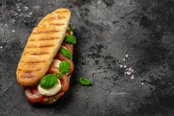 istock panini caprese with tomato, mozzarella and basil, Caprese Panini Sandwich. Delicious breakfast or snack, Clean eating, dieting, vegan food concept. top view 1449737573