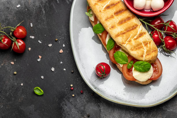 istock panini caprese with tomato, mozzarella and basil, Caprese Panini Sandwich. Delicious breakfast or snack, Clean eating, dieting, vegan food concept. top view 1449737576