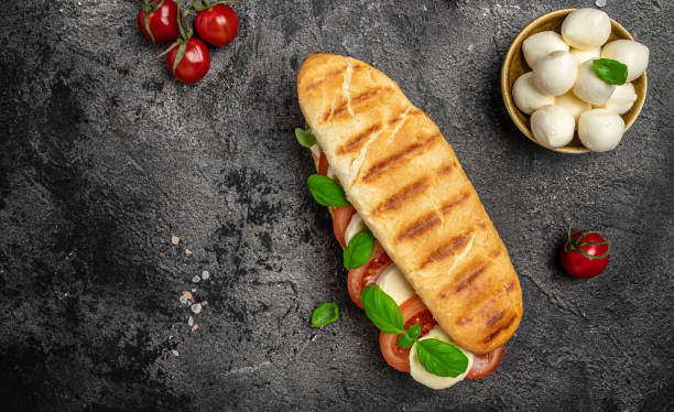 istock panini caprese with tomato, mozzarella and basil, Caprese Panini Sandwich. Delicious breakfast or snack, Clean eating, dieting, vegan food concept. top view 1449737581