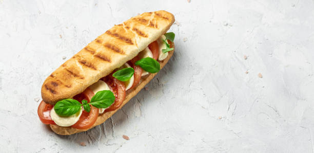 istock Pressed and toasted panini caprese with tomato, mozzarella and basil, Caprese Panini Sandwich. Delicious breakfast or snack, Clean eating, dieting, vegan food concept. top view 1449737583