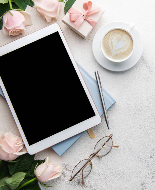istock Bouquet of roses and tablet  on concrete background. 1449738081
