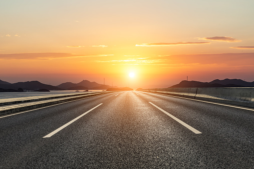 Asphalt road and mountain with beautiful sky clouds at sunset