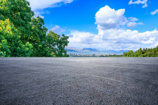 istock Asphalt road and green tree background 1449754062