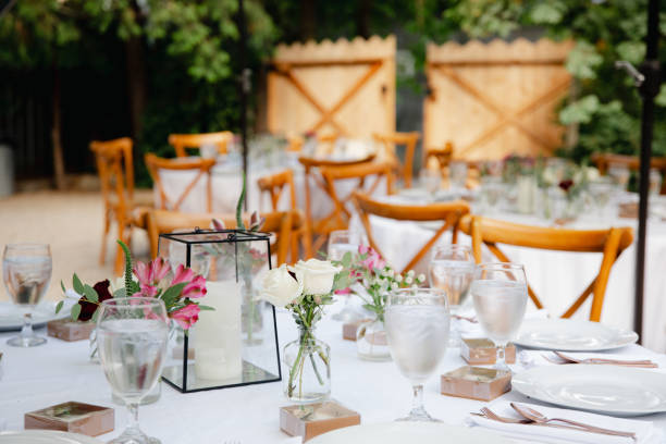 istock Backyard wedding reception - round tables with white tablecloths, vintage lanterns, roses and hyacinth,  and bentwood chairs 1449764384