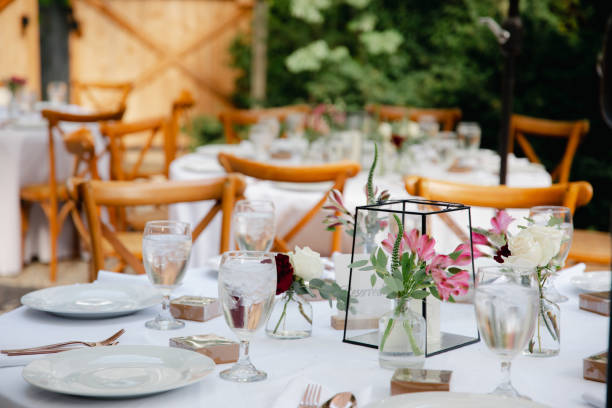 istock Backyard wedding reception - round tables with white tablecloths, vintage lanterns, roses and hyacinth,  and bentwood chairs 1449764385