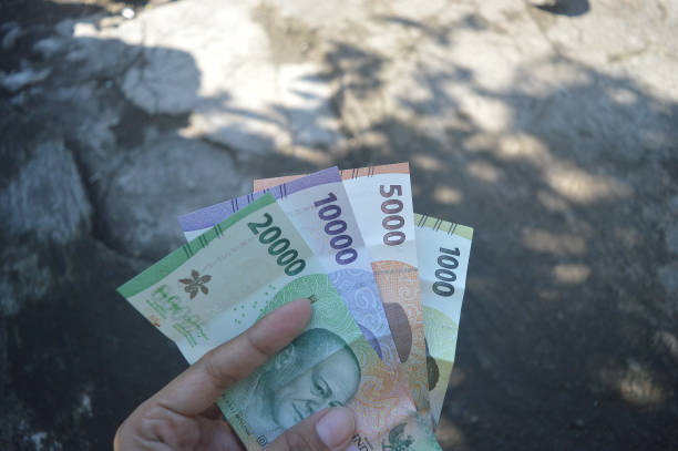 istock One thousand, Five thousands, ten thousands, twenty thousands rupiah banknote, Indonesia new paper currency on hand 1449765353