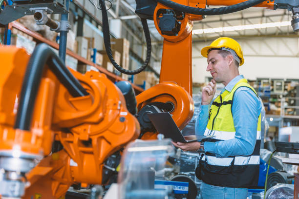 istock Caucasian engineer male worker working in metal factory with robot welding machine programmer controller and monitor. 1449766283
