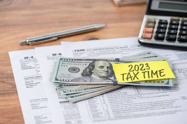 The 2020 TAX TIME note is on the hundred dollar bill. Tax concept stock photo