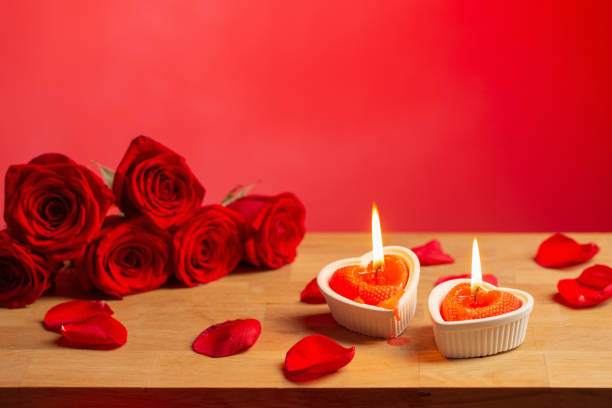 istock red roses with burning candles on red background 1449775600