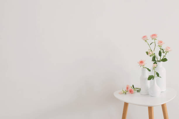 istock pink roses in white vase on  table on background white wall 1449775622