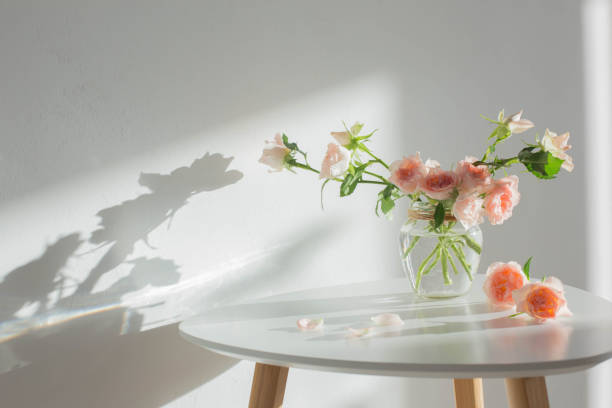 istock pink roses in glass jar on white modern table on background white wall 1449775626