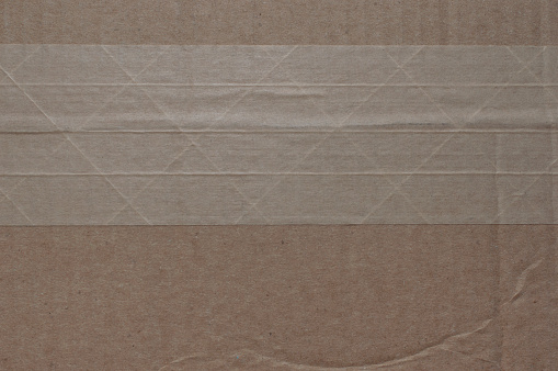 Cardboard texture with X pattern tape across