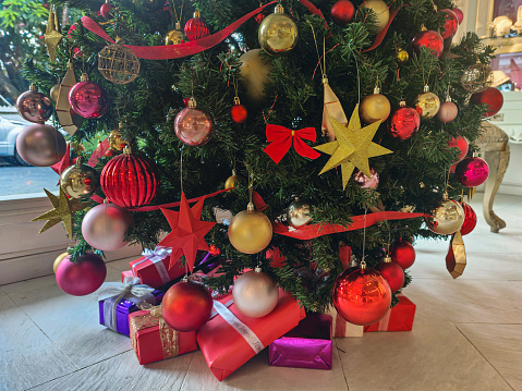 Close-up shot of christmas presents stack underneath of christmas tree