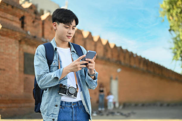 istock Asian man tourist using smartphone platform applications for helping tourism about travel map GPS. 1449780935
