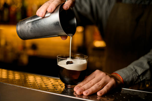 istock hand of bartender accurate pours whipped cream from shaker into glass 1449781680