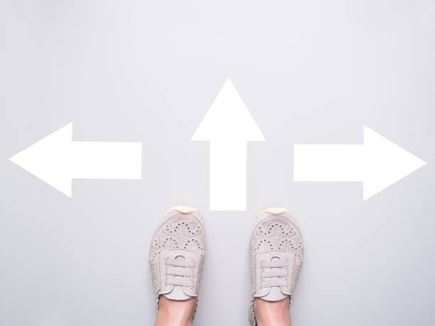 istock Foot Standing on White Wall with Sign Arrow Change Way 1449783203