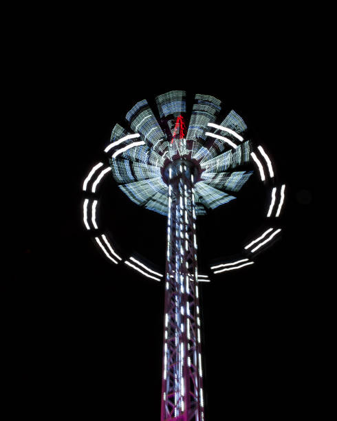 attrazione illuminata rotante nel parco divertimenti di notte. - ferris wheel wheel blurred motion amusement park foto e immagini stock