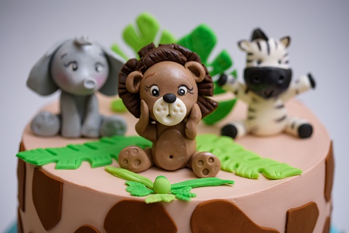 A closeup of a cake with marzipan animal decorations for kids