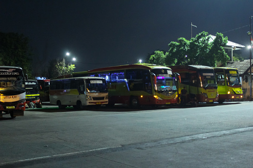 Jakarta, Indonesia December 04,2022 : line of intercity buses at the bus station at night. Kalideres bus station atmosphere