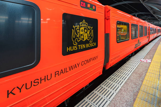 Closeup on the orange color wagons of the limited express train Huis Ten Bosch operated by Kyushu Railway Company. kyushu, nagasaki - dec 08 2022: Closeup on the orange color wagons of the limited express train Huis Ten Bosch operated by Kyushu Railway Company adorned with the coat of arms of the Dutch theme park. huis ten bosch stock pictures, royalty-free photos & images