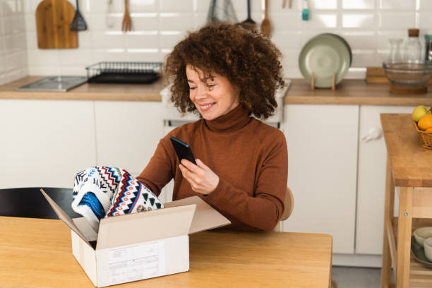 istock Happy young woman getting her order and using smartphone at home 1449788147