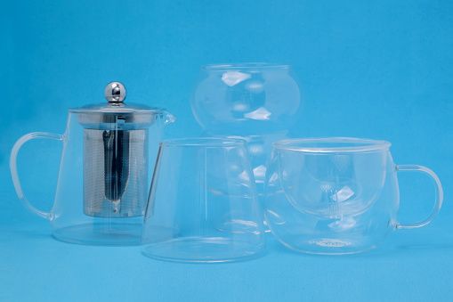 Set of transparent teapots on a blue background