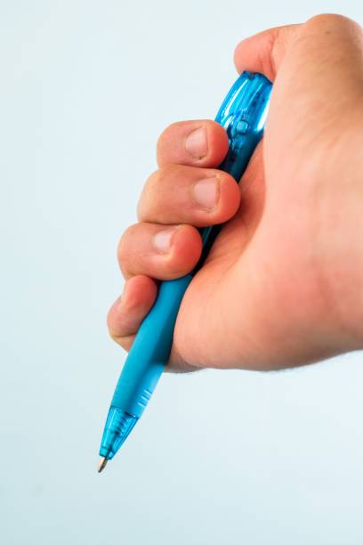 istock Hand holding a blue pen against a white background 1449791252