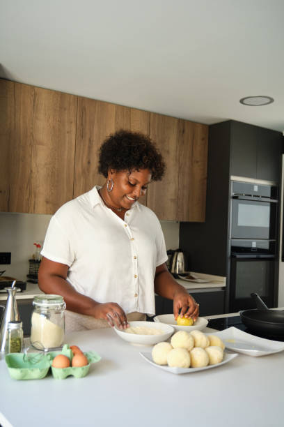 istock Young cuban woman breading mashed potatoes balls. 1449791293
