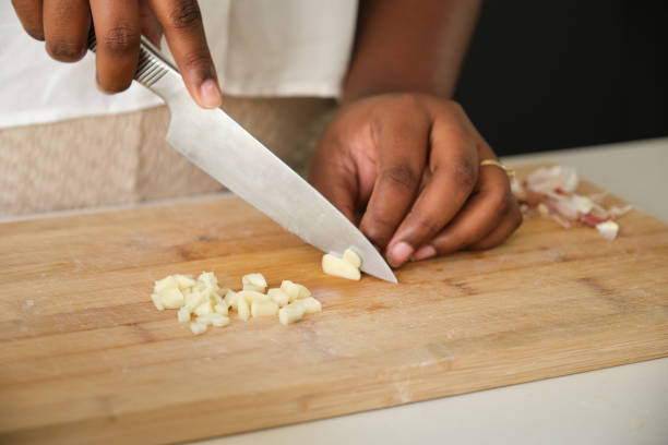 Close up of cuban woman hands cutting a raw garlic.