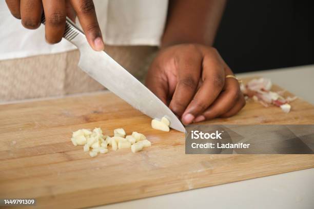 Close up of cuban woman hands cutting a raw garlic.