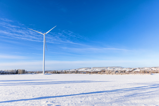 Wind turbine in a snowy field at a landscape view