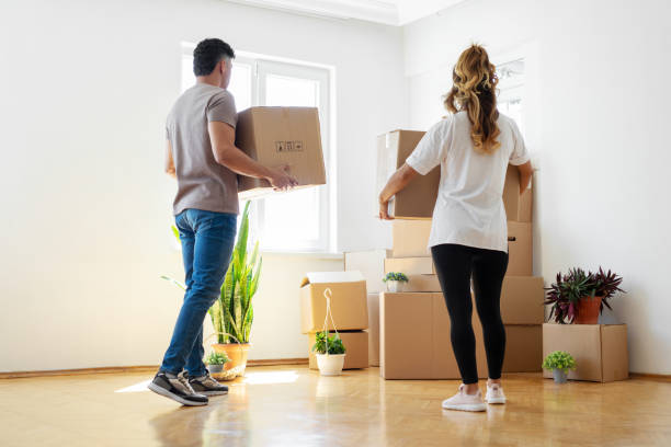 istock Couple holding boxes and moving in new house. 1449796166