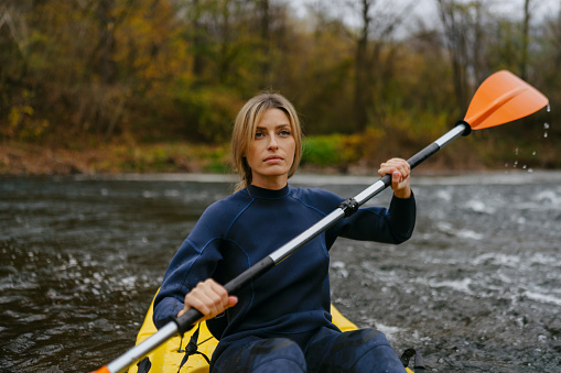 Photo of a young woman kayaking on the river
