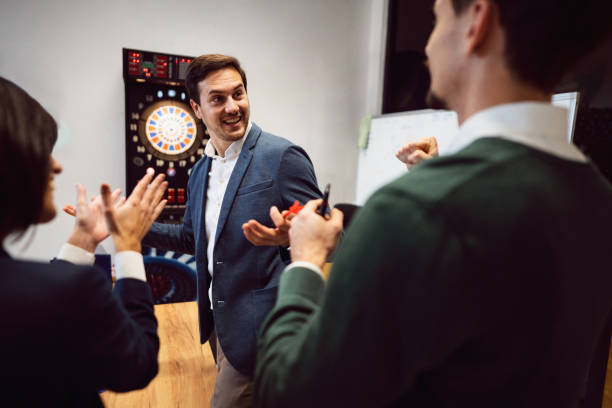 istock Business people playing darts at the office and having fun together 1449810121