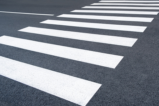 Freshly painted crosswalk. Asphalt marked on the road. new pedestrian zebra background in the city street