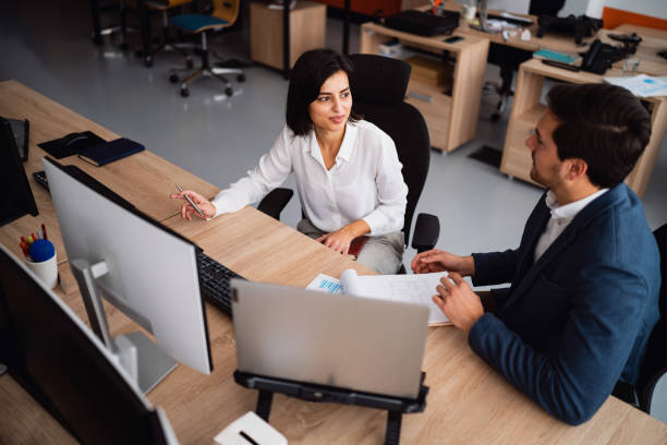 istock Two colleagues discussing business at their workplace 1449812065