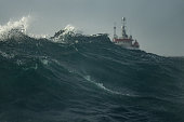 Fishing boat trawler sailing out at rough sea