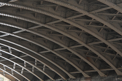 Close up of curved steelwork on underside of Victorian railway viaduct in Newcastle upon Tyne, England