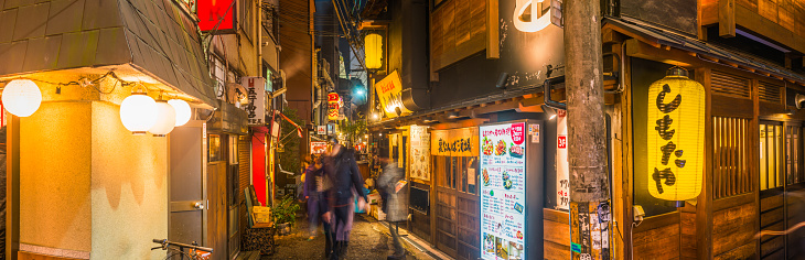 Traditional paper lanterns illuminating the narrow alleyways and popular restaurants of the Dotonbori Namba district of downtown Osaka at night, Japan.