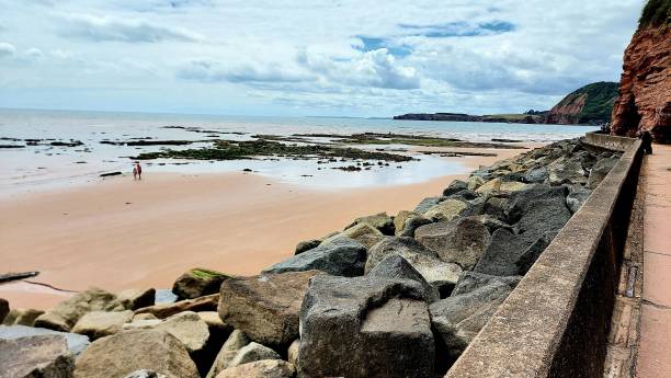 istock Rocky seaside wall on a beach under a cloudy sky 1449816215