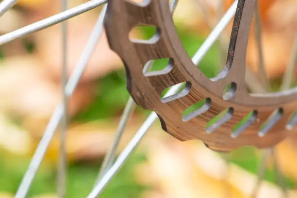 Photo of Bicycle disk brakes close up, grey metal disc attached to bike wheel, effective popular mountain bicycle brakes.