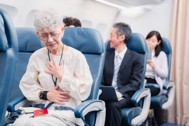 ältere frau leidet an krankheit im flugzeug - chest fly stock-fotos und bilder