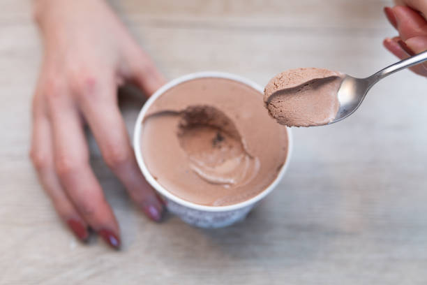istock Woman's hand eating chocolate ice cream 1449817769