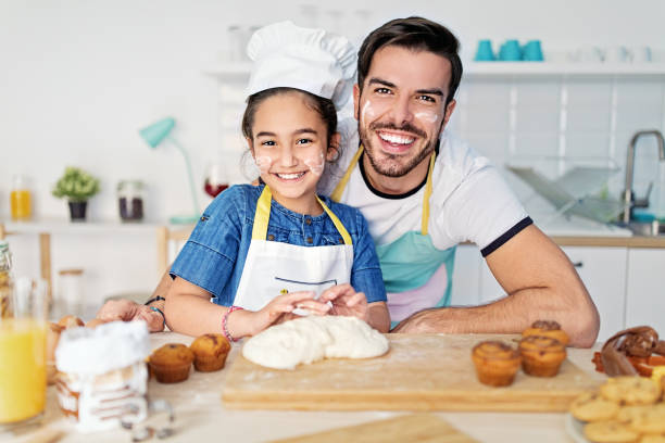 istock Father and daughter cooking together in a kitchen 1449818433