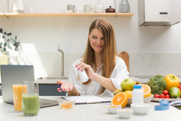 istock A young nutritionist advises a patient online on taking medications, dietary supplements, showing a jar of vitamins. 1449822576