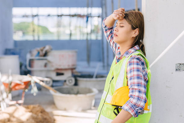 woman worker tired from work hard overwork fatigue be sick at construction site stock photo