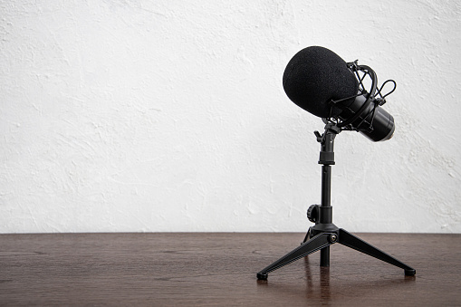Studio Condenser Microphone for home studio radio podcast isolated on white wall wooden table background space for text.